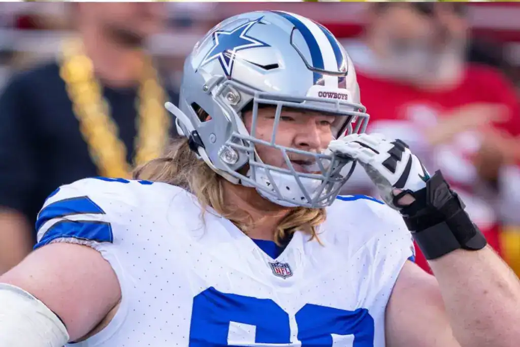 Dallas Cowboys offensive lineman T.J. Bass adjusts his helmet during a game.
