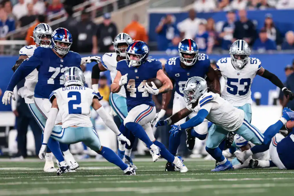 Dallas Cowboys defense trying to stop New York Giants running back Cam Skattebo.