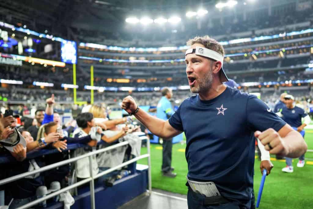 Dallas Cowboys head coach Brian Schottenheimer celebrates on the field ahead of the 2026 NFL Awards race.