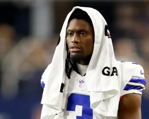 Dallas Cowboys wide receiver George Pickens stands with a towel over his head on the sideline of a Cowboys game.