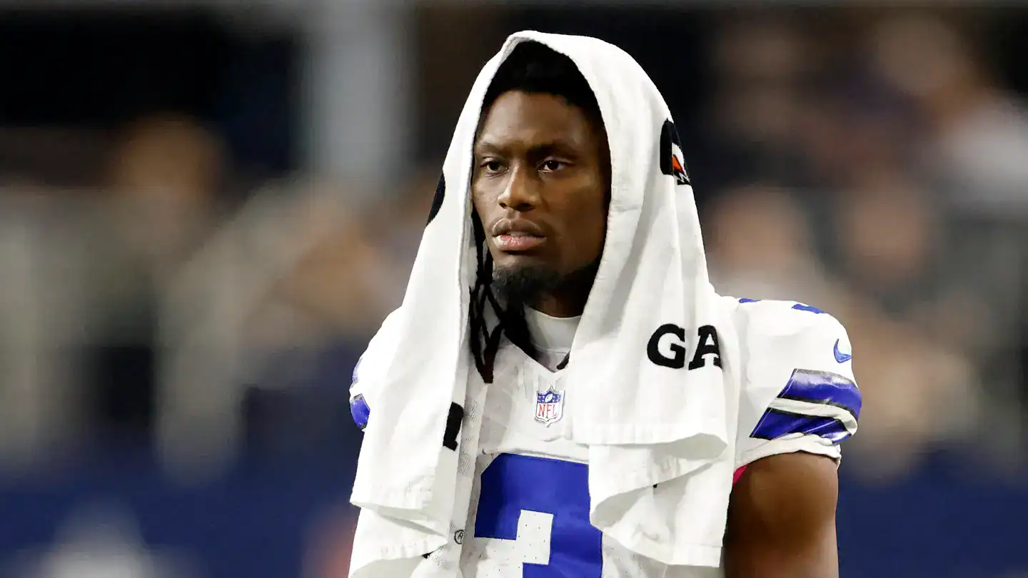 Dallas Cowboys wide receiver George Pickens stands with a towel over his head on the sideline of a Cowboys game.