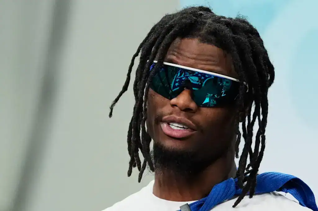 Dallas Cowboys wide receiver George Pickens weaing blue tinted sunglasses in street clothes. 