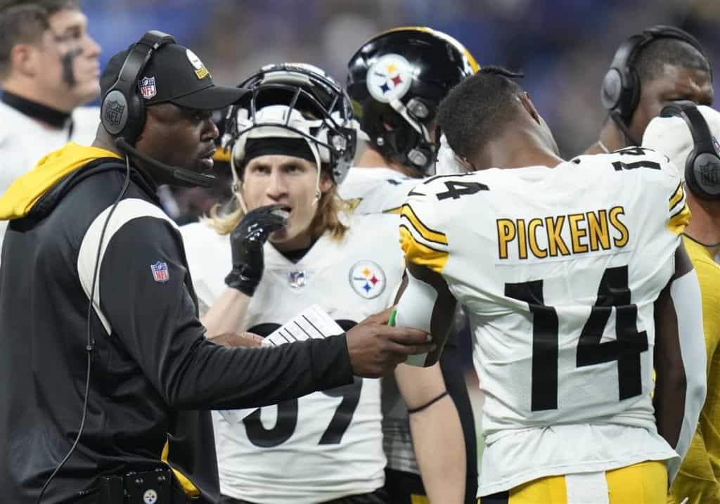 Former Pittsburgh Steelers head coach Mike Tomlin grabbing the arm of former wide receiver George Pickens on the sideline.