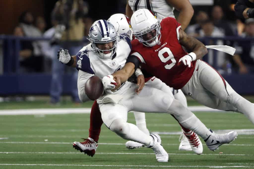 Dak Prescott getting hit by an Arizona Cardinals defender and getting the ball knocked loose in 2022. 