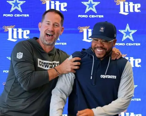 Dallas Cowboys coaches Christian Parker and Brian Schottenheimer laughing during Parker's introductory press conference.
