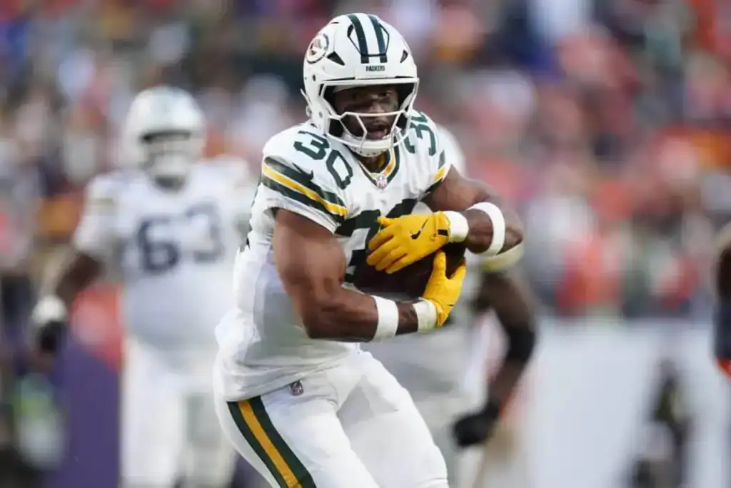 Cowboys vs. Packers: 5 Things to Watch Sunday Night Packers runnig back securing the ball as he runs towards the defense.