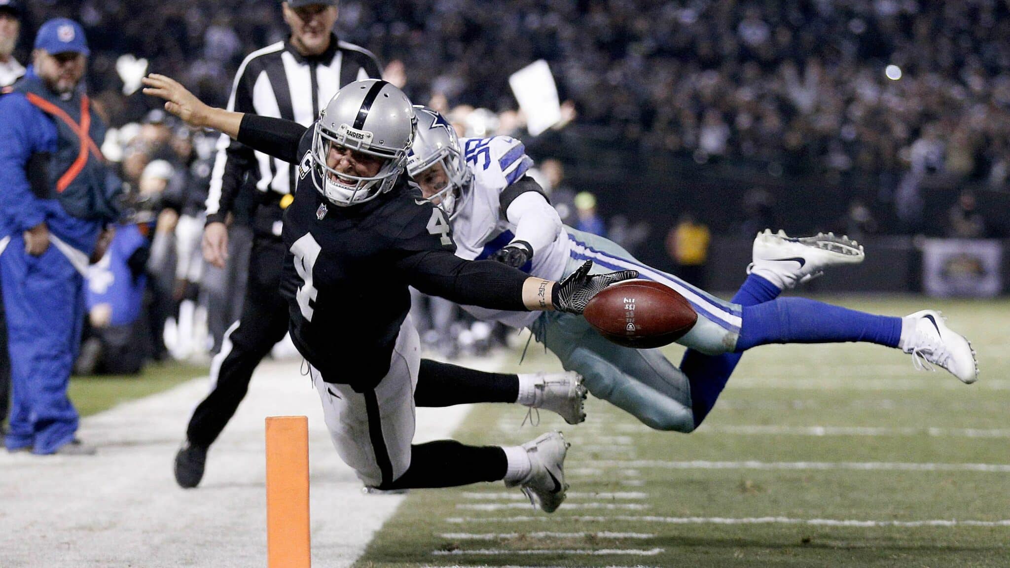 Dec 17, 2017; Oakland, CA, USA; Oakland Raiders quarterback Derek Carr (4) fumbles the ball out of the end zone against the Dallas Cowboys in the fourth quarter at Oakland Coliseum. Mandatory Credit: Cary Edmondson-USA TODAY Sports