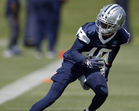 Nahshon Wright, in a blue and white uniform, practices diligently on the football field.