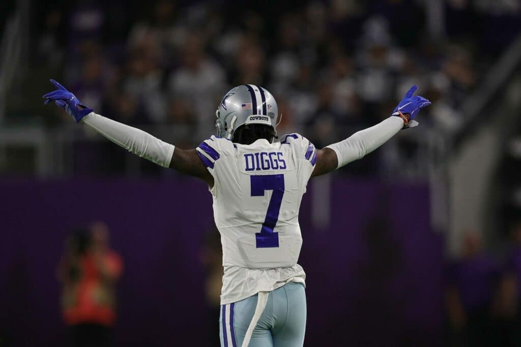 Dallas Cowboys cornerback Trevon Diggs in his white Cowboys uniform holding his arms in the air pointing his fingers. Cowboys' Secondary + Pass Rush = A Surprise 2025 Powerhouse
