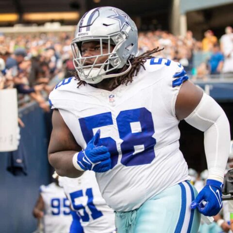 Football player wearing a Dallas Cowboys uniform with number 58 runs onto the field.