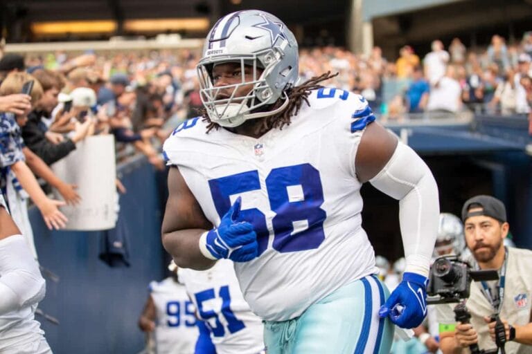 Football player wearing a Dallas Cowboys uniform with number 58 runs onto the field.