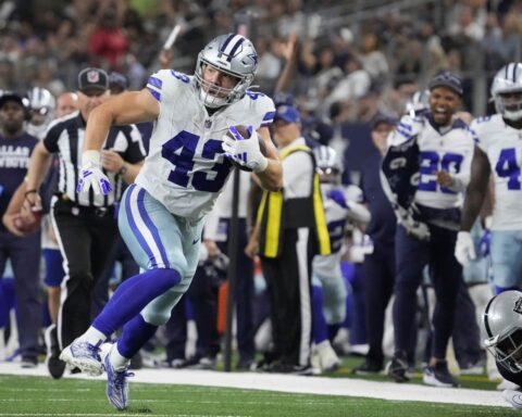 Hunter Luepke, in his Cowboys uniform, charges down the field with the ball, while both teammates and 49ers opponents focus on every move.