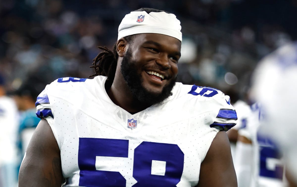 Smiling football player Mazi Smith in a white and blue uniform with the number 58 on the field.