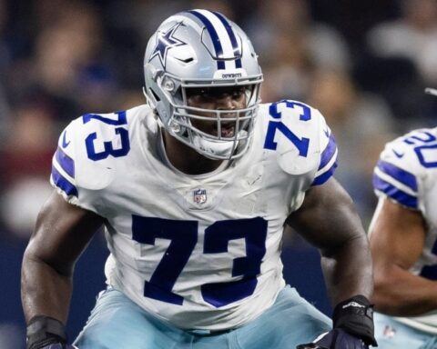 Tyler Smith, wearing number 73 in a white and blue uniform, prepares to block during the game.