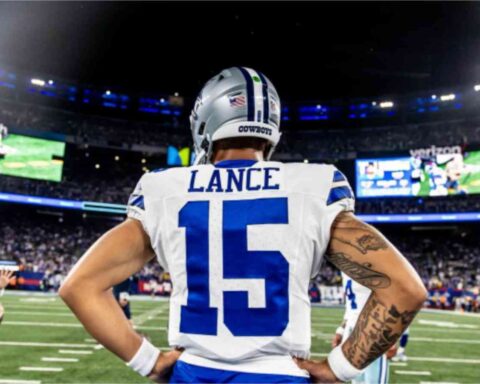 Football player with "Lance" and number 15 on jersey stands with hands on hips, facing a stadium full of spectators.