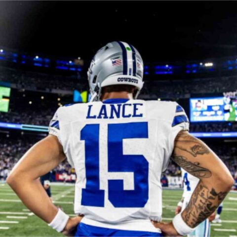 Football player with "Lance" and number 15 on jersey stands with hands on hips, facing a stadium full of spectators.