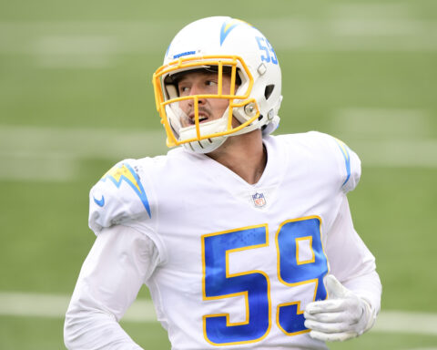 Football player wearing a white and yellow uniform with number 59 on the field.