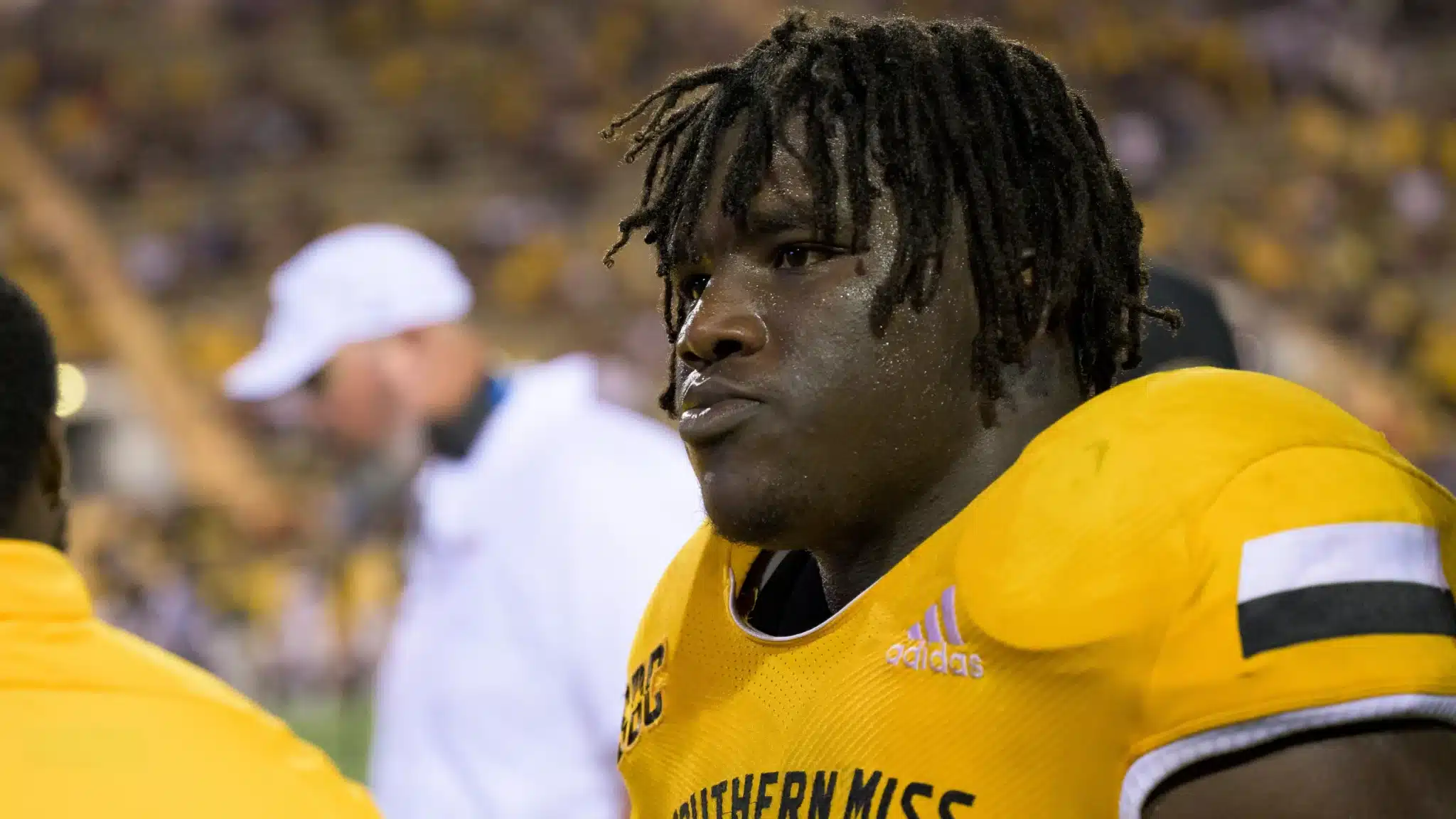 Close-up of a football player in a yellow jersey with the logo "Southern Miss" during a game.