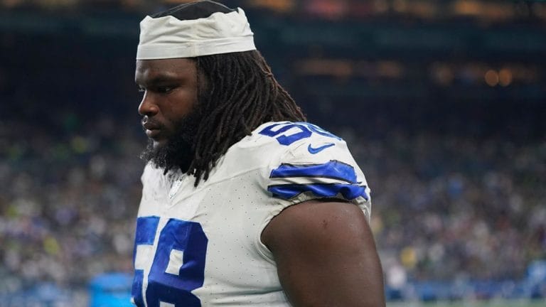 A football player in a white and blue uniform, numbered 68, standing on the field with a focused expression.