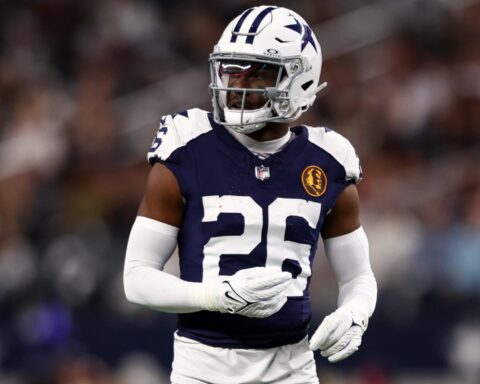 Football player in a Dallas Cowboys uniform and helmet on the field during a game.