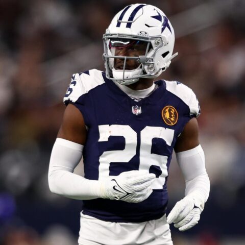 Football player in a Dallas Cowboys uniform and helmet on the field during a game.