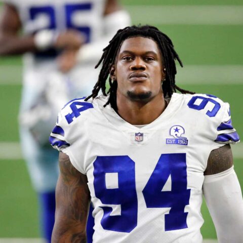 A football player wearing a white jersey with the number 94, standing on the field.