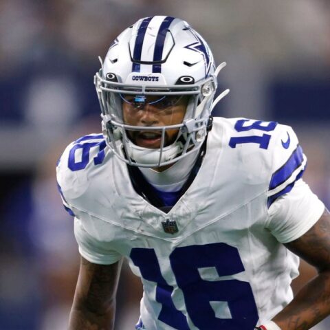 Football player in a blue and white uniform, wearing a helmet marked with "Cowboys," on the field during a game.