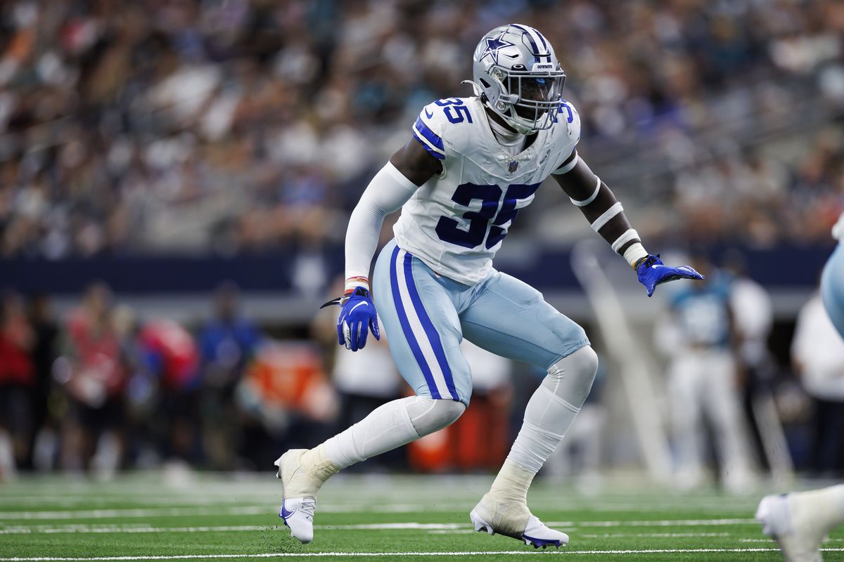 A football player wearing a white and blue uniform with the number 35 prepares to make a play during a game.