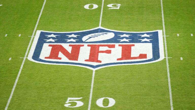 The NFL logo proudly adorns the 50-yard line, flanked by yard markers on lush green turf, as if waiting for a flawless play from the Dallas Cowboys.