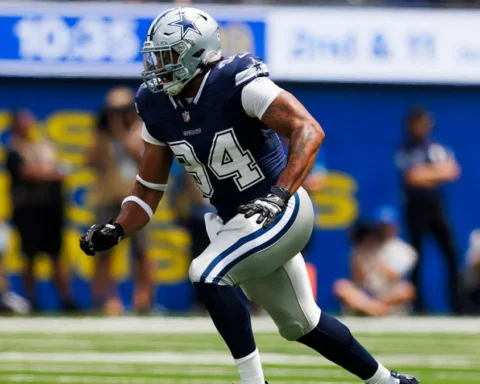 A football player in a blue and white uniform runs on the field during a game.