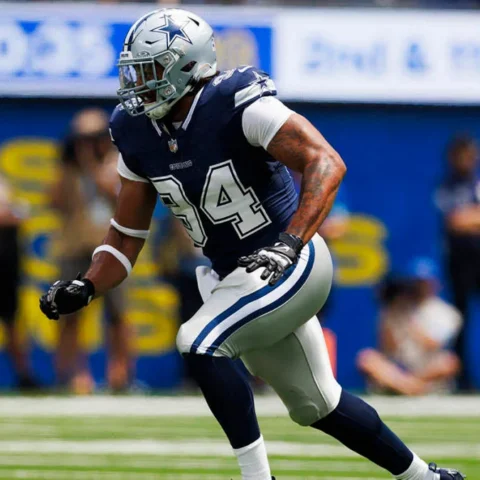A football player in a blue and white uniform runs on the field during a game.