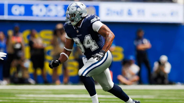 A football player in a blue and white uniform runs on the field during a game.