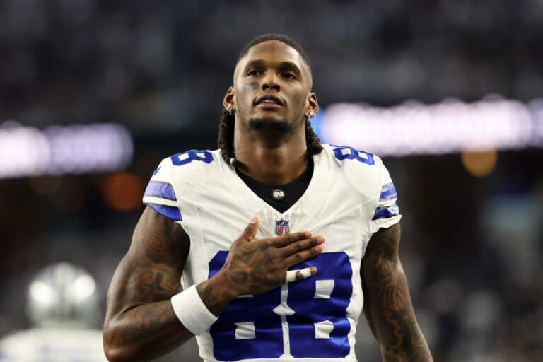 Football player wearing a white jersey with number 88, resembling CeeDee Lamb from the Cowboys, stands with his right hand on his chest as if in a heartfelt moment during Week 11.