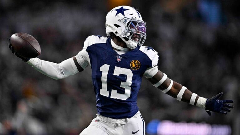 During a game, a football player in a blue and white uniform from the Cowboys draft class throws a precise pass, highlighting the team's 2024 resurgence.