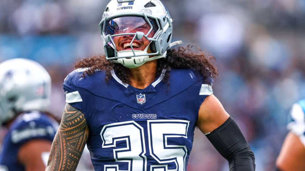 Football player wearing a silver helmet with long curly hair coming from underneath, wearing a blue jersey with the number 35 across the chest. 3 Shocking Reasons Matt Eberflus Will Transform the Cowboys Defense