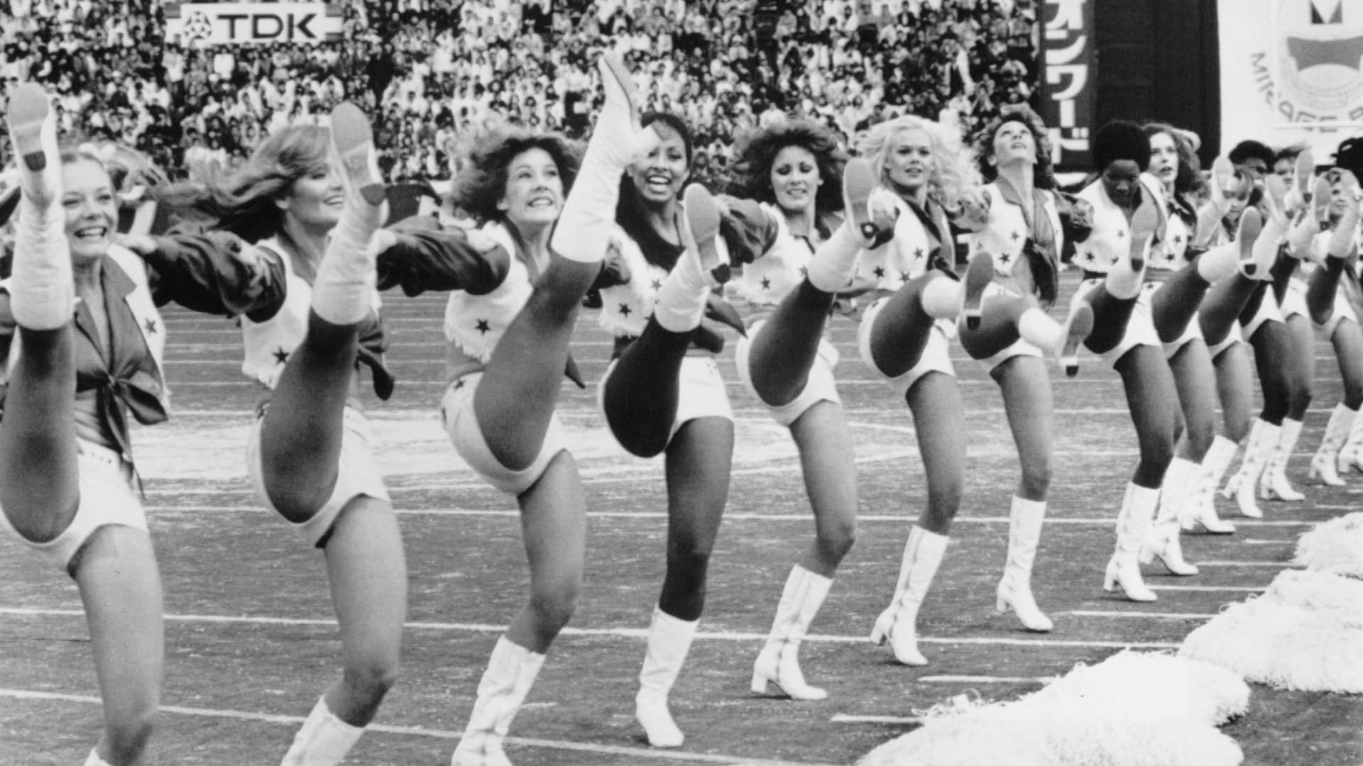 Vintage black and white photo of the legendary Dallas Cowboys Cheerleaders Iconic kick line. Cowboys Cheerleaders: Netflix Sparked a 400% Raise