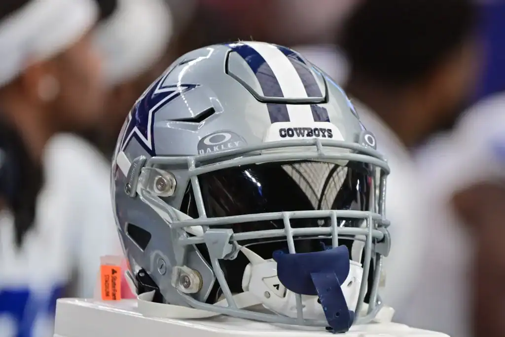 Dallas Cowboys helmet sitting on the back of the Cowboys bench on the sideline of the football field. The Ultimate Dallas Cowboys 2025 Playoffs Prediction
