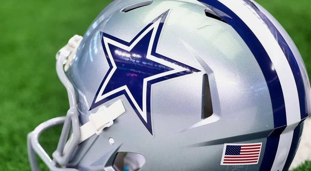 Dallas Cowboys helmet sitting on a football field. Blue Lights and Silver Helmets: 5 Cowboys Arrests That Didn't Stop the Show