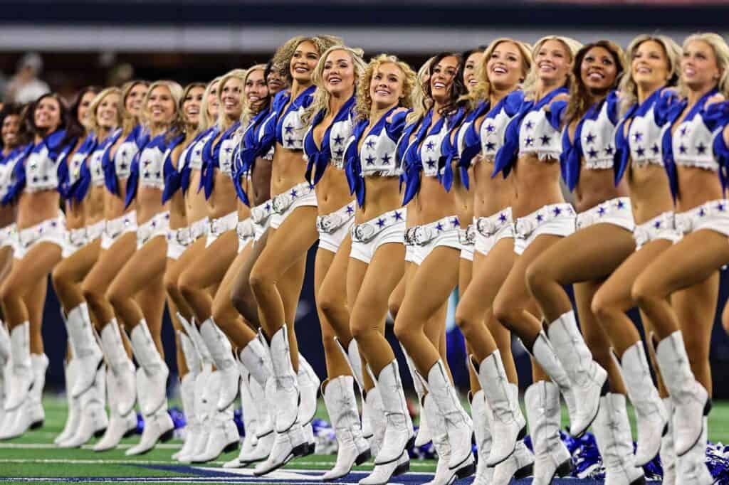 Dallas Cowboys Cheerleaders lined up in a kick line dance routine. Stars, Stripes, and the Star: Cowboys Resonate on the Fourth of July