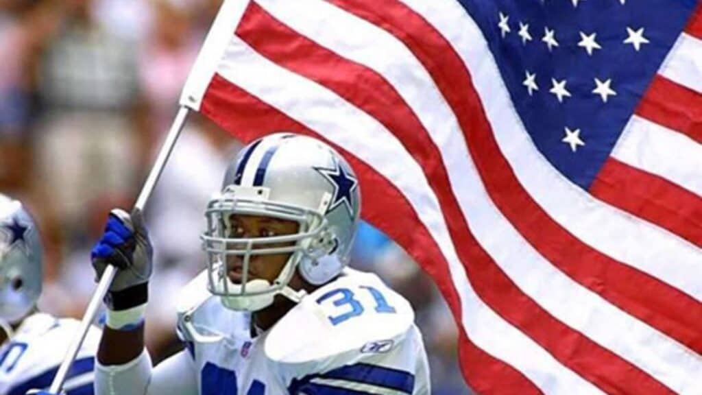 Dallas Cowboys former player George Teague carrying the American Flag. Stars, Stripes, and the Star: Cowboys Resonate on the Fourth of July