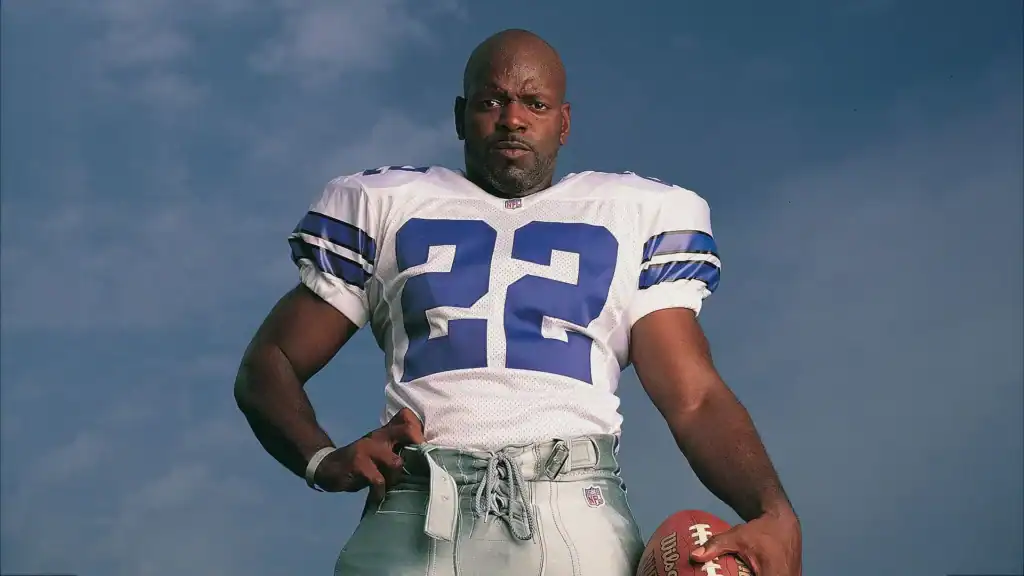 Dallas Cowboys Emmitt Smith standing in a white Dallas Cowboys jersey staring at the camera. The GOAT of the Dallas Cowboys