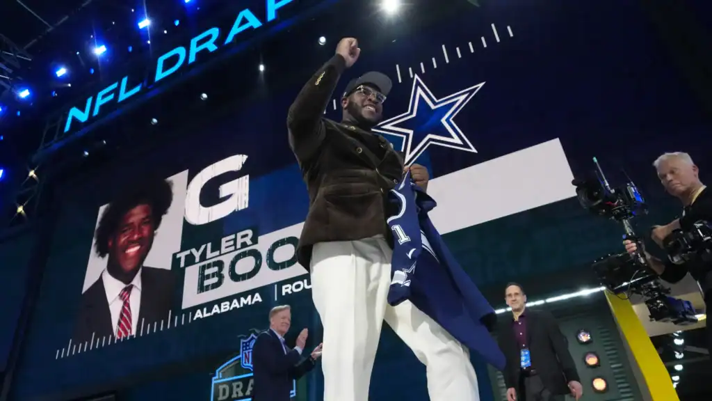 Dallas Cowboys draft pick Tyler Booker walking across the NFL Draft stage. Cowboys 2025 Rookie Class Poised for Big Impacts
