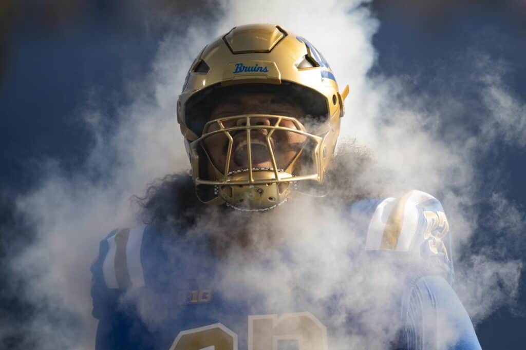 UCLA Bruins defensive tackle Jay Toia running through smoke and onto the football field. 1 Rookie Everyone's Overlooking Could Save the Cowboys
